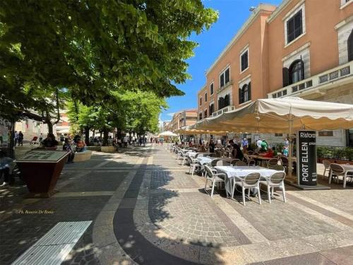 a street with tables and chairs and buildings and trees at CITy CENTER in Cosenza