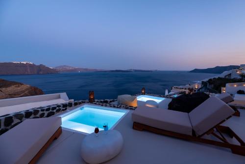 a villa with a swimming pool on a roof at Twenty One Suites in Oia
