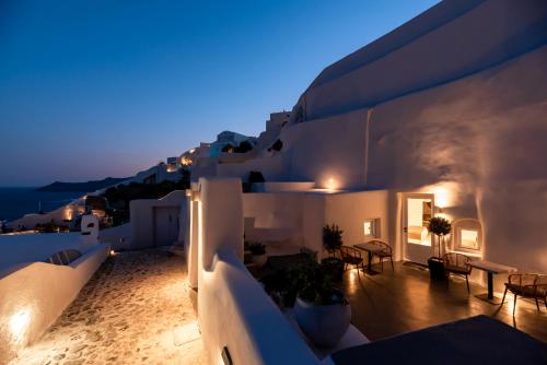 a balcony of a house at night with lights at Twenty One Suites in Oia