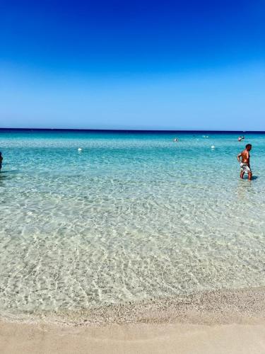 a man standing in the water at the beach at Suite Battisti 7 in Lecce
