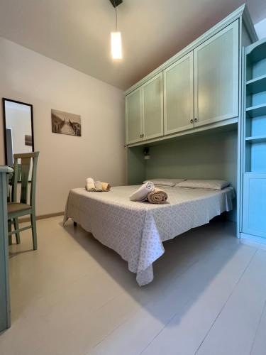 1 dormitorio con 1 cama y 1 silla en Appartamento Veronese, en Olbia