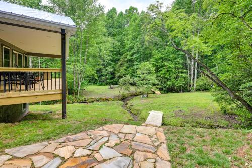 a house with a porch and a yard with a stone walkway at Creekside Cabin in Franklin about 8 Mi to Downtown! in Franklin