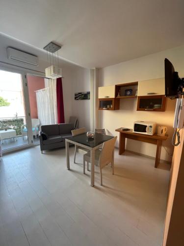 ein Wohnzimmer mit einem Tisch und einem Sofa in der Unterkunft Appartamento Veronese in Olbia