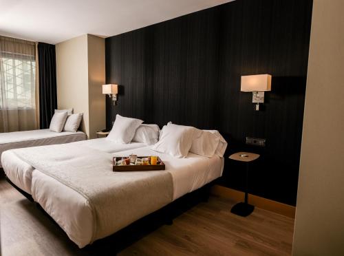 a hotel room with two beds and a tray of food at Hotel Plaza in A Coruña