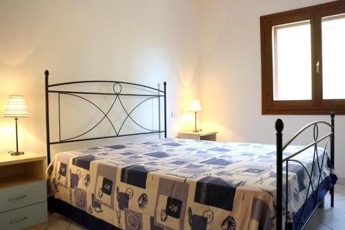 サンタ・テレーザ・ガッルーラにあるResidence Olimpo Poseidoneのベッドルーム1室(ベッド1台、ランプ2つ、窓付)