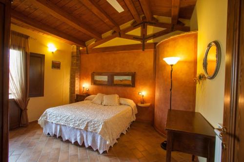 MontelopioにあるBio Agriturismo Pratiniのベッドルーム(ベッド1台、テーブル、ランプ付)