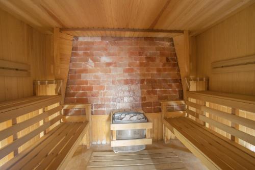 a room with a brick fireplace in a wooden cabin at Bushi Resort & SPA in Skopje