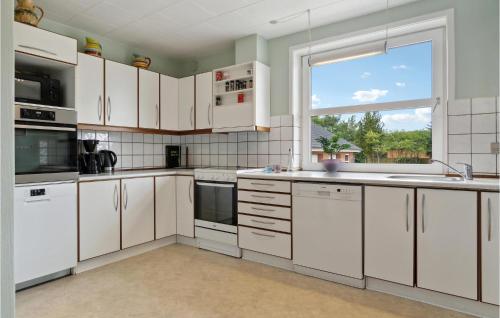 a kitchen with white cabinets and a large window at Lovely Home In Grindsted With Wifi in Grindsted