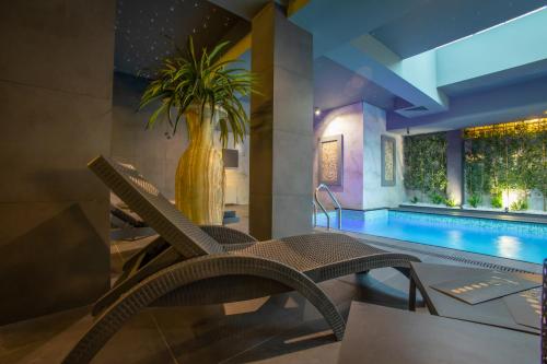 a pool with a chair and a vase with a plant at Bushi Resort & SPA in Skopje