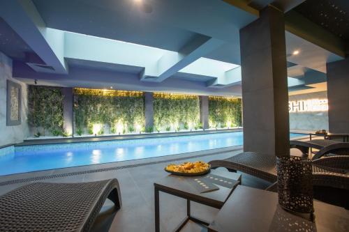 a swimming pool with a table and chairs next to it at Bushi Resort & SPA in Skopje