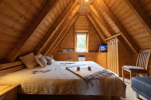 um quarto num chalé de madeira com uma cama grande em KS 14 - Strandvogt 2 Komfort em Dorum Neufeld