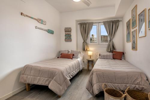 a bedroom with two beds and a window at Flat just 280 m from the beach in Can Picafort