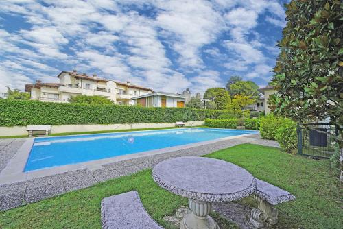 una piscina con tavolo di fronte a una casa di Appartamento Mazzini P1-25 by Wonderful Italy a Sirmione