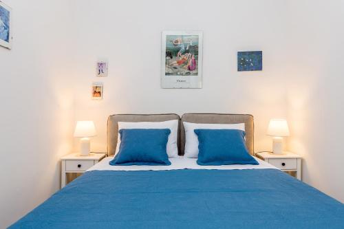 a bedroom with a blue bed with two blue pillows at Holiday house EDEN in Rasopasno