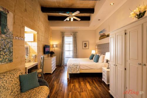 Schlafzimmer mit einem Bett und einem Deckenventilator in der Unterkunft Rest, restore, explore. An exclusive stay in Malta in Żebbuġ