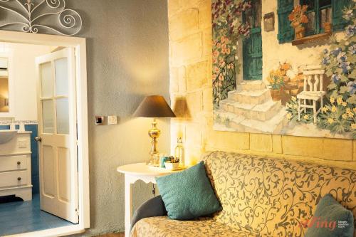una habitación con sofá y una pintura en la pared en Rest, restore, explore. An exclusive stay in Malta, en Żebbuġ