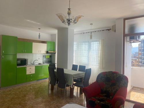 a kitchen with green cabinets and a table and chairs at Center of Shkodra Apartment in Shkodër