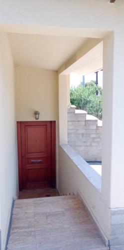 a hallway with a red door and stairs at Christina's Apartment in Stratónion