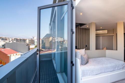 a balcony with a bed and a view of the city at Hotel Plaza in A Coruña