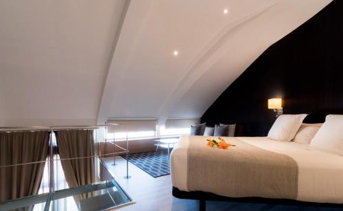 a bedroom with a large bed with a black ceiling at Hotel Plaza in A Coruña