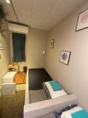 a small bedroom with a bed and a window at 54Journey Roppongi in Tokyo