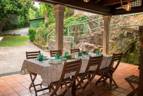 een tafel en stoelen op een patio bij Molino verde in Coirós