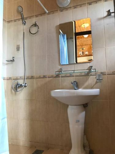ein Bad mit einem Waschbecken, einem Spiegel und einer Dusche in der Unterkunft Legenda Health Resort in Kaji-Say