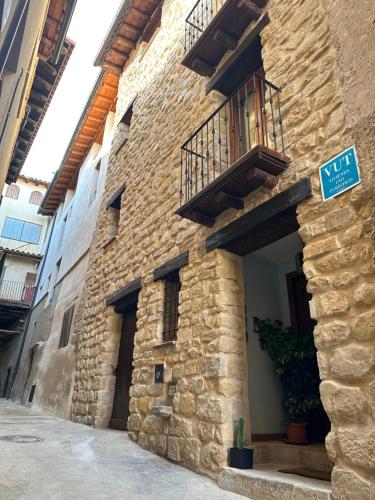 ein Steingebäude mit einem Balkon und einem Straßenschild in der Unterkunft Apartamento La Fonteta in La Fresneda