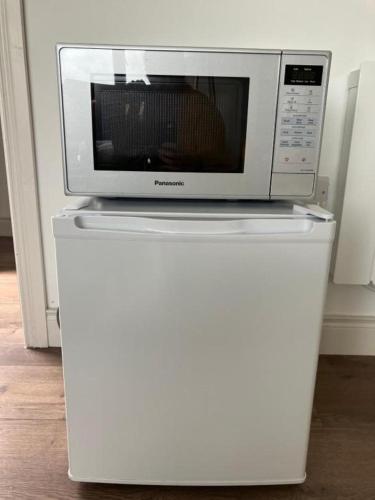 a microwave sitting on top of a white refrigerator at New studio near Lahinch, Doolin & Cliffs of Moher in Lahinch