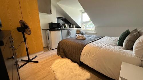 a bedroom with a bed and a tripod in a room at Economic Studio in the heart of Chiswick - London in London