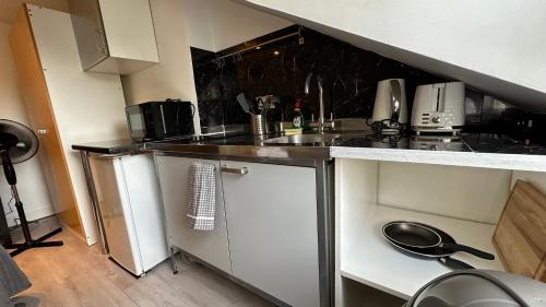 a small kitchen with a sink and a counter top at Economic Studio in the heart of Chiswick - London in London