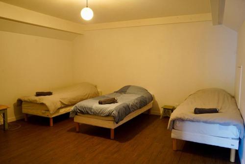 two twin beds in a room with wooden floors at Gîte de l’Ambiance in Francheville