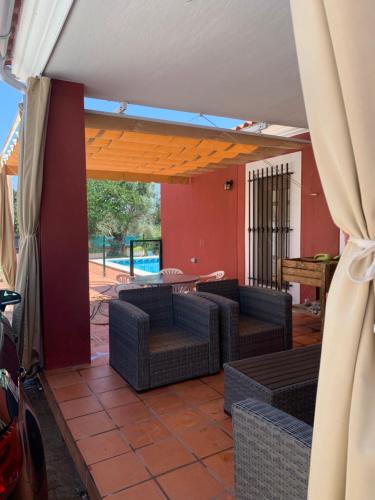 a patio with couches and a table in a room at Casa situada en un entorno natural Casa Rural La Serena in Trujillo
