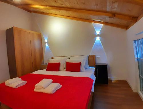 a bedroom with a red and white bed with towels on it at Mati Apartments Prishtina in Pristina