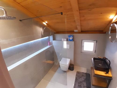 a small bathroom with a toilet and a window at Mati Apartments Prishtina in Pristina