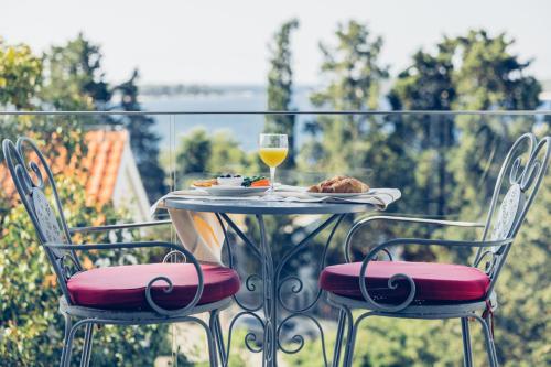 einen Tisch mit einem Teller Essen und einem Glas Wein in der Unterkunft Pharia Hotel and Apartments - by the beach in Hvar