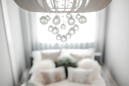 a room with a white couch and a chandelier at Apartament Staszica Nowa Sól in Nowa Sól