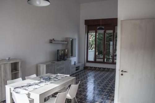 une salle à manger avec une table et des chaises blanches dans l'établissement Casa Arco, à Torre Suda