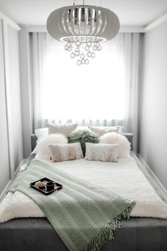 a bedroom with a large bed with a chandelier at Apartament Staszica Nowa Sól in Nowa Sól