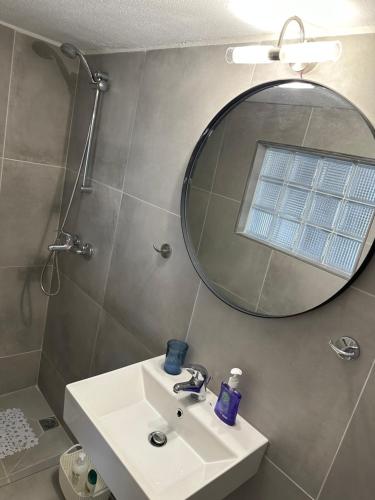 La salle de bains est pourvue d'un lavabo et d'un miroir. dans l'établissement Syra nest private beach, à Liaropá