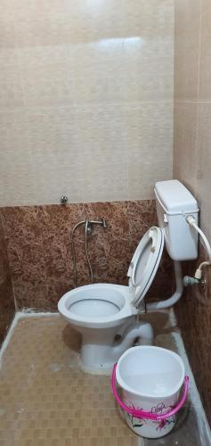a bathroom with a toilet and a bowl at Hallima Service Apartments Home Stay purpose Guest House 4 in Pudukkottai