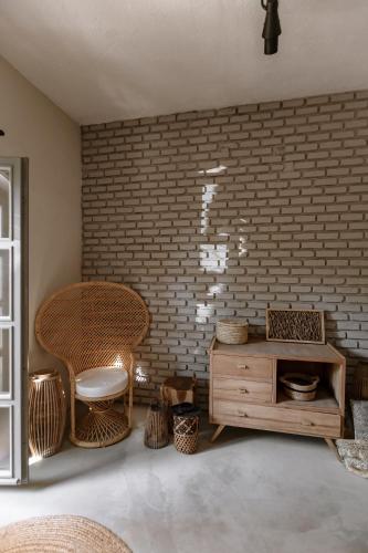 a room with a brick wall and a table and chairs at GAIA Alaçatı Bazaar in Alacati