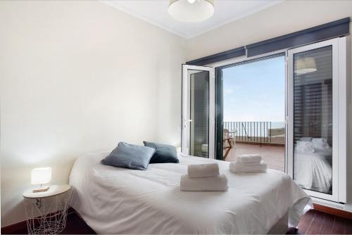 a bedroom with a white bed and a large window at Penthouse Vista Mar in Funchal