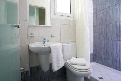 a white bathroom with a sink and a toilet at Villa Marina in Lefkada