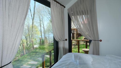 um quarto com uma cama e uma grande janela em MANZARA SUİTES ORMAN KÖY em Kartepe