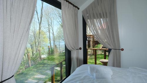 a bedroom with a bed and a large window at MANZARA SUİTES ORMAN KÖY in Kartepe