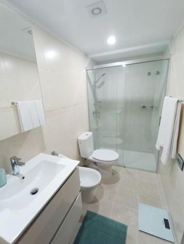 a white bathroom with a toilet and a shower at Apartamento Idaira Sun in Los Cristianos