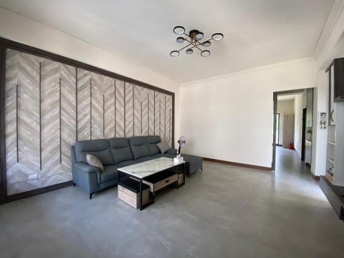 a living room with a blue couch and a table at Muchen BnB in Magong