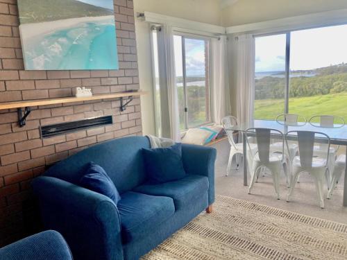 uma sala de estar com um sofá azul e uma mesa em Paradise View em Augusta