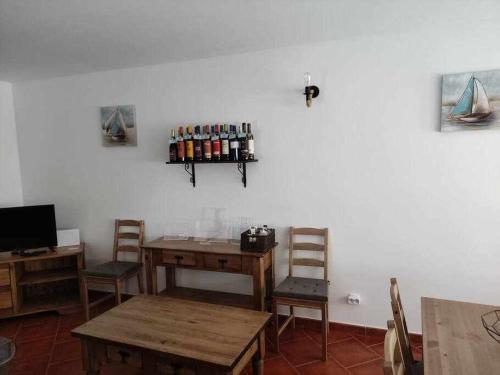 a room with a table and chairs and a shelf with bottles at Di&Ana II - Alojamento Vila Viçosa in Vila Viçosa